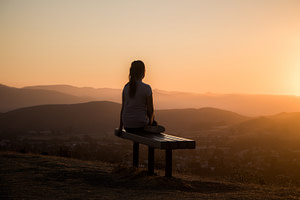 Image of woman facing sun and meditating